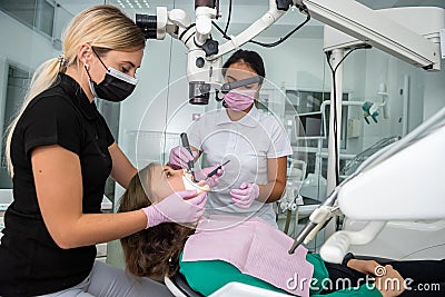 Dentist uses professional equipment to whiten the patient`s teeth in the clinic Stock Photo