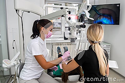 Dentist uses professional equipment to whiten the patient`s teeth in the clinic Stock Photo