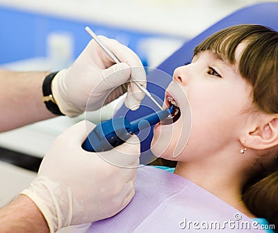 Dentist using dental filling gun on kid Stock Photo