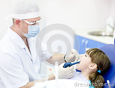 Dentist using dental filling gun on kid Stock Photo