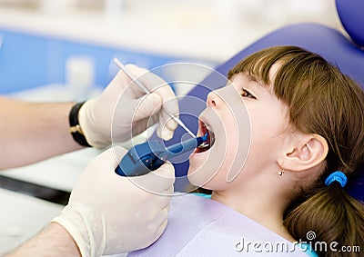 Dentist using dental filling gun on kid Stock Photo