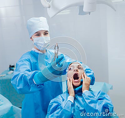 Dentist using surgical pliers to remove a decaying tooth. Stock Photo