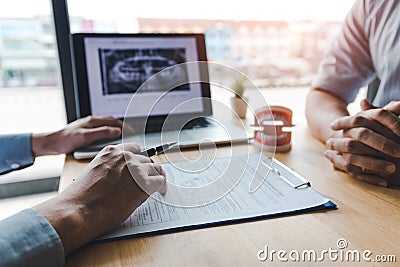 Dentists are discussing dental problems at report x-ray image on laptop screen to patients Stock Photo