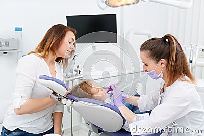 Dentists making treatment for little girl Stock Photo