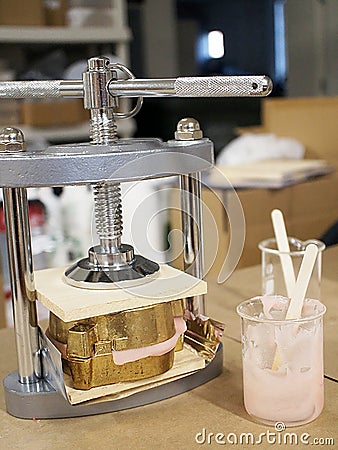 Denture Making Process, resin and teeth held under the press Stock Photo