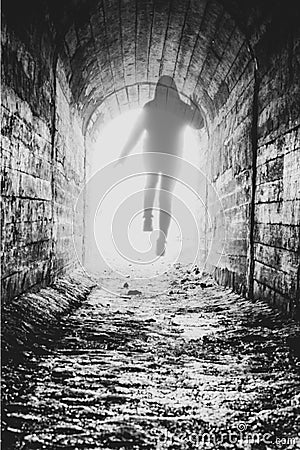 The departing soul of the girl at the end of the tunnel. transparent human form in a milky glow. black and white photo Stock Photo