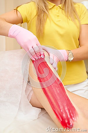 depilation and beauty concept - procedure of hair removing on leg beautiful woman with sugar paste or wax honey and pink Stock Photo