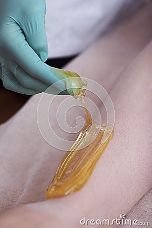 Depilatory Procedure with Sugar Paste. Removing Hair on Women`s legs. Procedure sugaring in a beauty salon. Close Up Stock Photo