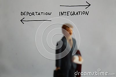 Deportation and integration handwritten text with arrows left and right. Blurry miniature man is going to integration way Stock Photo