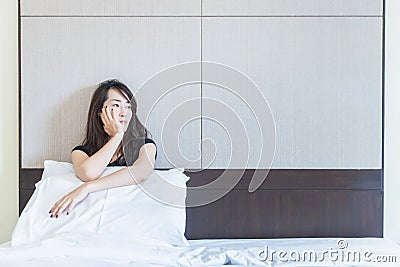 depress woman sitting on bed in room Stock Photo