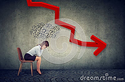 Depressed businesswoman looking down at the falling arrow feeling confused has many questions Stock Photo