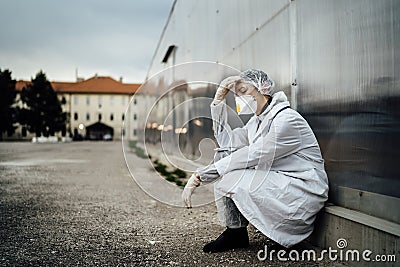 Depressed crying doctor with mask having mental breakdown.Fear,anxiety,panic attack due to coronavirus outbreak.Psychological Stock Photo
