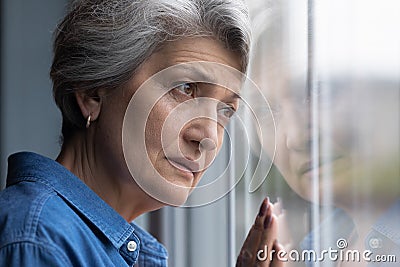 Depressed elderly hispanic lady widow mourning for gone husband Stock Photo