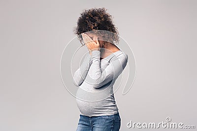 Depressed expectant lady closing her face and crying Stock Photo