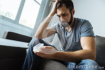 Depressed gloomy man holding a pill organizer Stock Photo