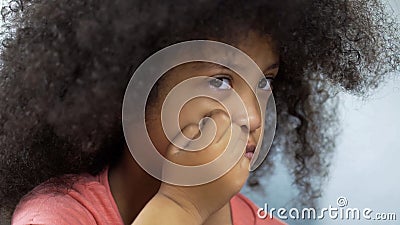 Depressed little girl suffering Down syndrome sitting at table, healthcare Stock Photo