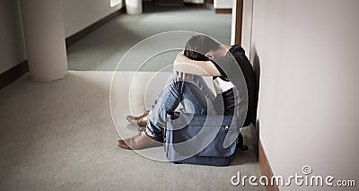 Depressed male student with head on knees Stock Photo