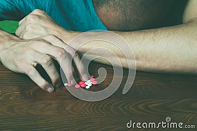 Depressed man suffering from suicidal depression want to commit suicide by taking strong medicament drugs and pills. Stock Photo