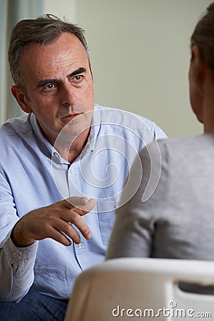 Depressed Mature Man Talking To Counsellor Stock Photo