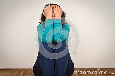 Depressed and sad woman with hands on her face Stock Photo