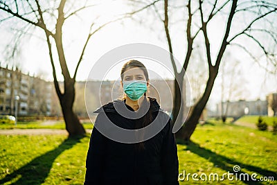 Depressed scared person wearing a mask to prevent contracting disease in spring nature.Coronavirus pandemic life.Panic and fear of Stock Photo
