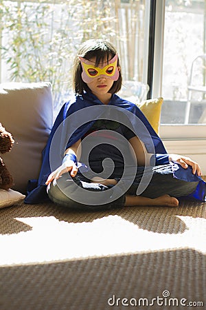 Depressed superhero child being lonely, stressed out meditating into thyself Stock Photo