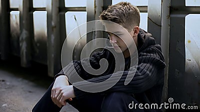 Depressed teen feeling lonely, sitting in abandoned house, no support and care Stock Photo