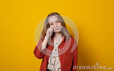 Depressed teen girl wipes tears cries from despair has displeased sad face expression wears neat clothes faces unsolvable problems Stock Photo