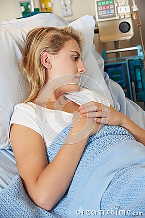 Depressed Teenage Female Patient Lying In Hospital Bed Stock Photo