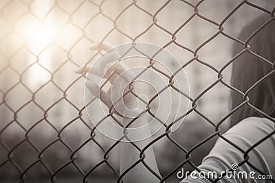 Depressed, trouble, help and chance. Hopeless women raise hand on chain-link fence ask for help Stock Photo