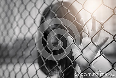 Depressed, trouble, help and chance. Hopeless women raise hand on chain-link fence ask for help Stock Photo