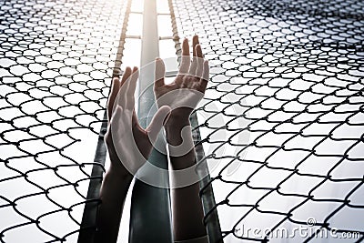 Depressed, trouble, help and chance. Hopeless women raise hand over chain-link fence ask for help Stock Photo