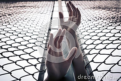 Depressed, trouble, help and chance. Hopeless women raise hand over chain-link fence ask for help Stock Photo