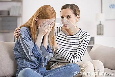 Depressed woman comforted by friend Stock Photo