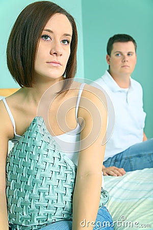 Depressed Young Caucasian Couple Sit On Bed Side Stock Photo