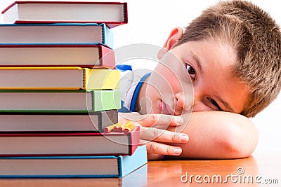 Depressed young schoolboy eyeing his textbooks Stock Photo