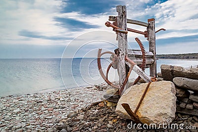 Derelict old boat winch on the pebble beach at historic Jordhamn, Ã–land, Sweden Stock Photo