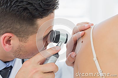 Dermatologist checking mole on woman Stock Photo
