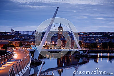 Derry, Ireland. Illuminated Peace bridge in Derry Londonderry, City of Culture, in Northern Ireland with city center at Editorial Stock Photo