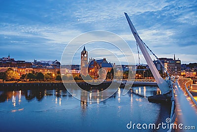 Derry, Ireland. Illuminated Peace bridge in Derry Londonderry, City of Culture, in Northern Ireland with city center at Editorial Stock Photo