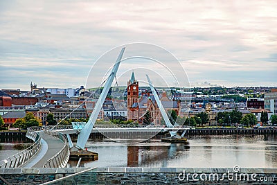 Derry, Ireland. Illuminated Peace bridge in Derry Londonderry, City of Culture, in Northern Ireland with city center at Editorial Stock Photo