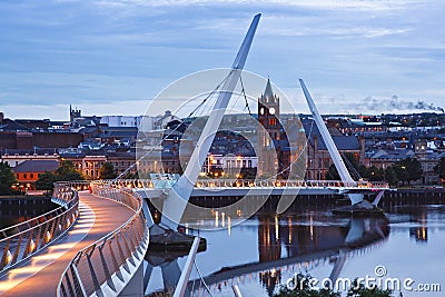 Derry, Ireland. Illuminated Peace bridge in Derry Londonderry, City of Culture, in Northern Ireland with city center at Editorial Stock Photo