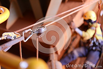 2 descenders 2 low stretch rope access equipment rigging as a tie line tension rope defocused rope access technician working Stock Photo