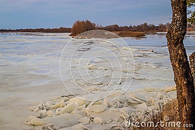 The descent of ice in the spring on the river in March is a natural phenomenon against the sky and clouds in the evening Stock Photo