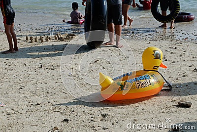 Lampung, Indonesia - May 15, 2022: Yellow duck swim tire for kids washed up on the beach Editorial Stock Photo