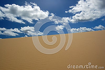 Desert dune and white clouds Stock Photo