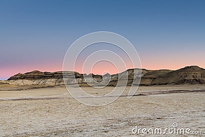 The glowing sky of sunset over the desert landscape of the Bisti Badlands of New Mexico Stock Photo