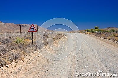 Desert landscape view of a sharp left turn sign on a dirt road i Stock Photo