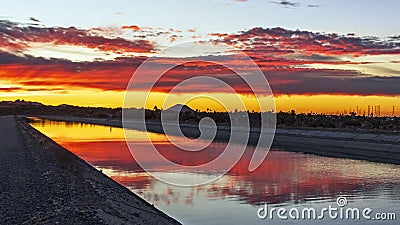 Vibrant Desert Sunrise Mirror Refection On Water Stock Photo
