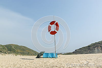 Deserted beach on the Atlantic coast. Lifebuoy on the pole. Neighborhood of Lisbon, Portugal Stock Photo